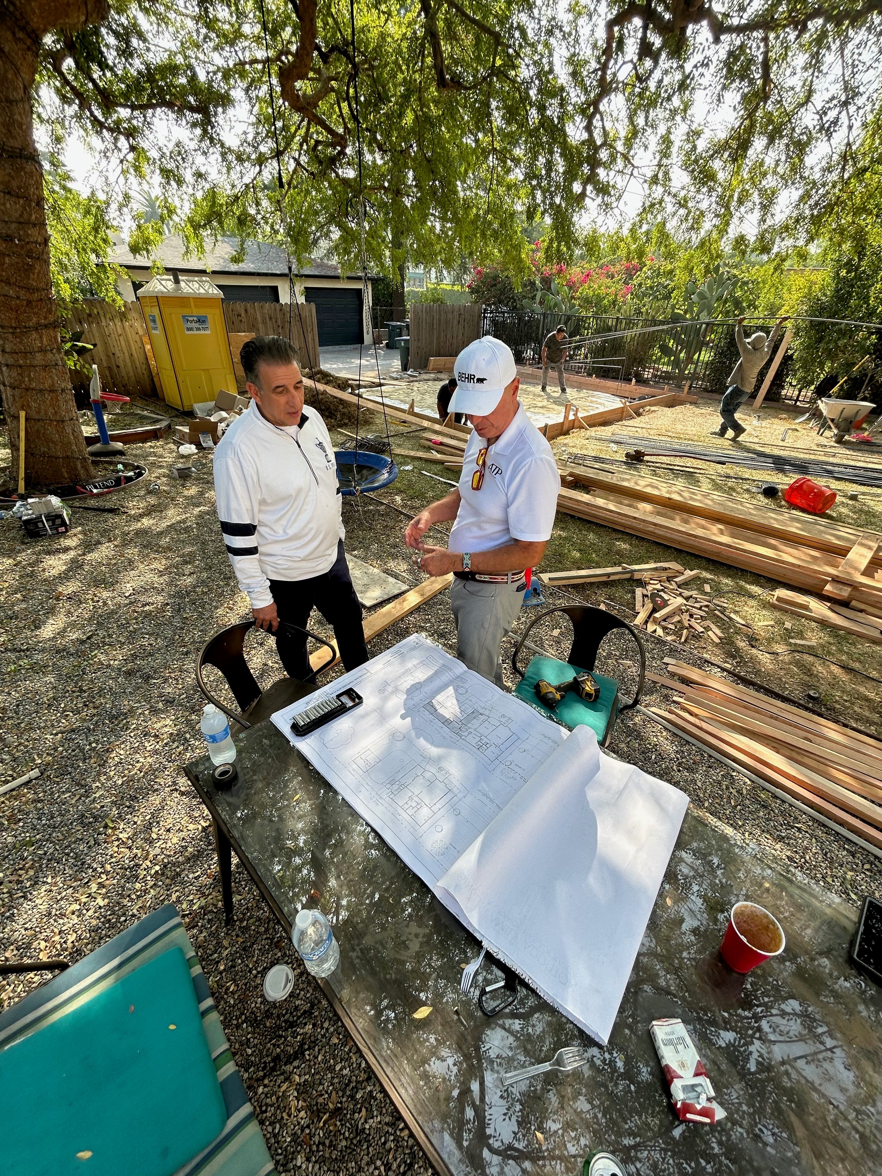 Two people reviewing construction plans at an outdoor job site.