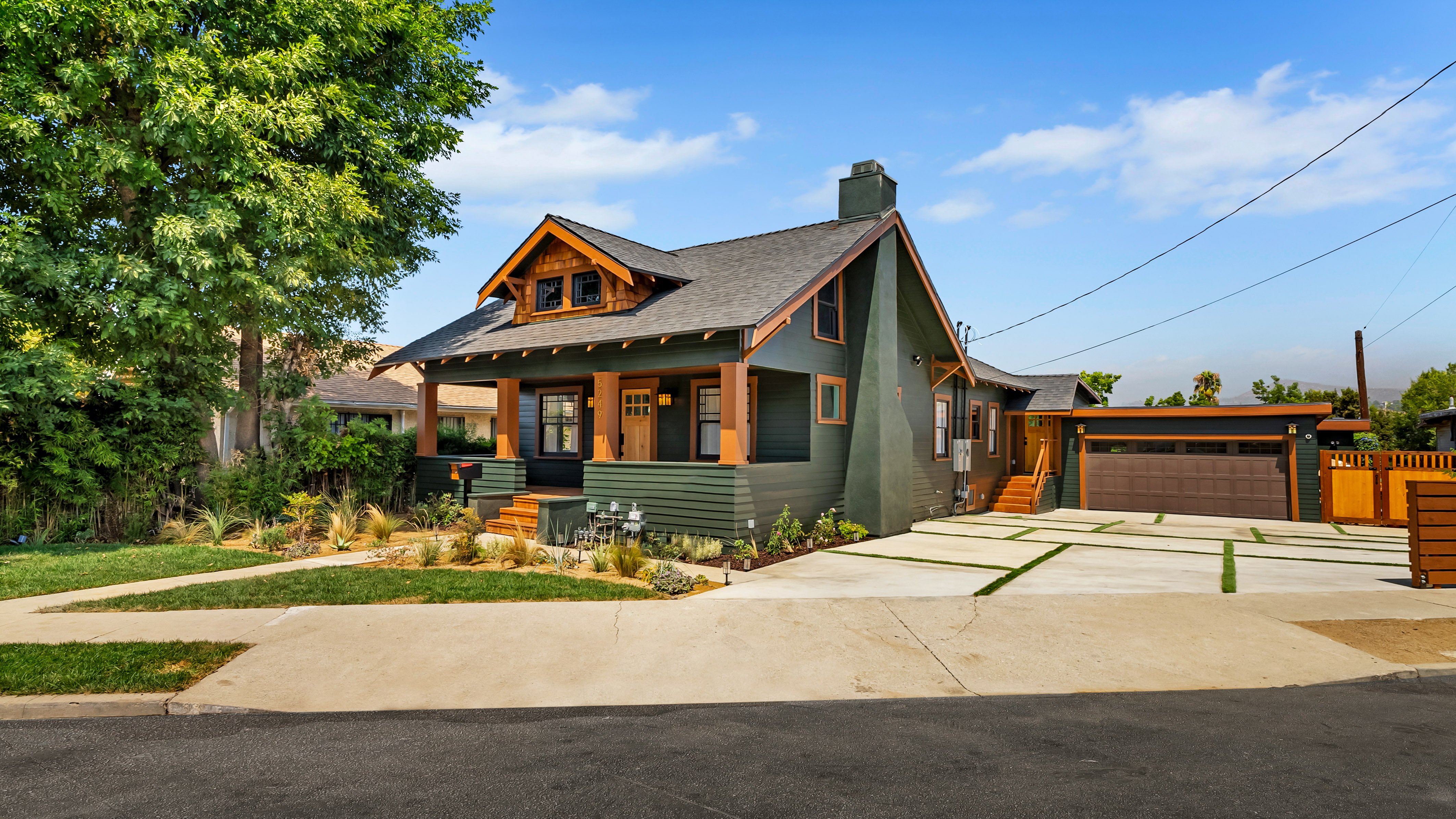 Rustic Craftsman-style home with dark wood exterior and large front porch.