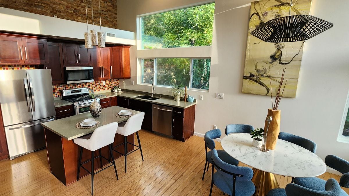 Contemporary open-concept kitchen with wood cabinetry, stainless steel appliances, and natural light, modern residential interior design
