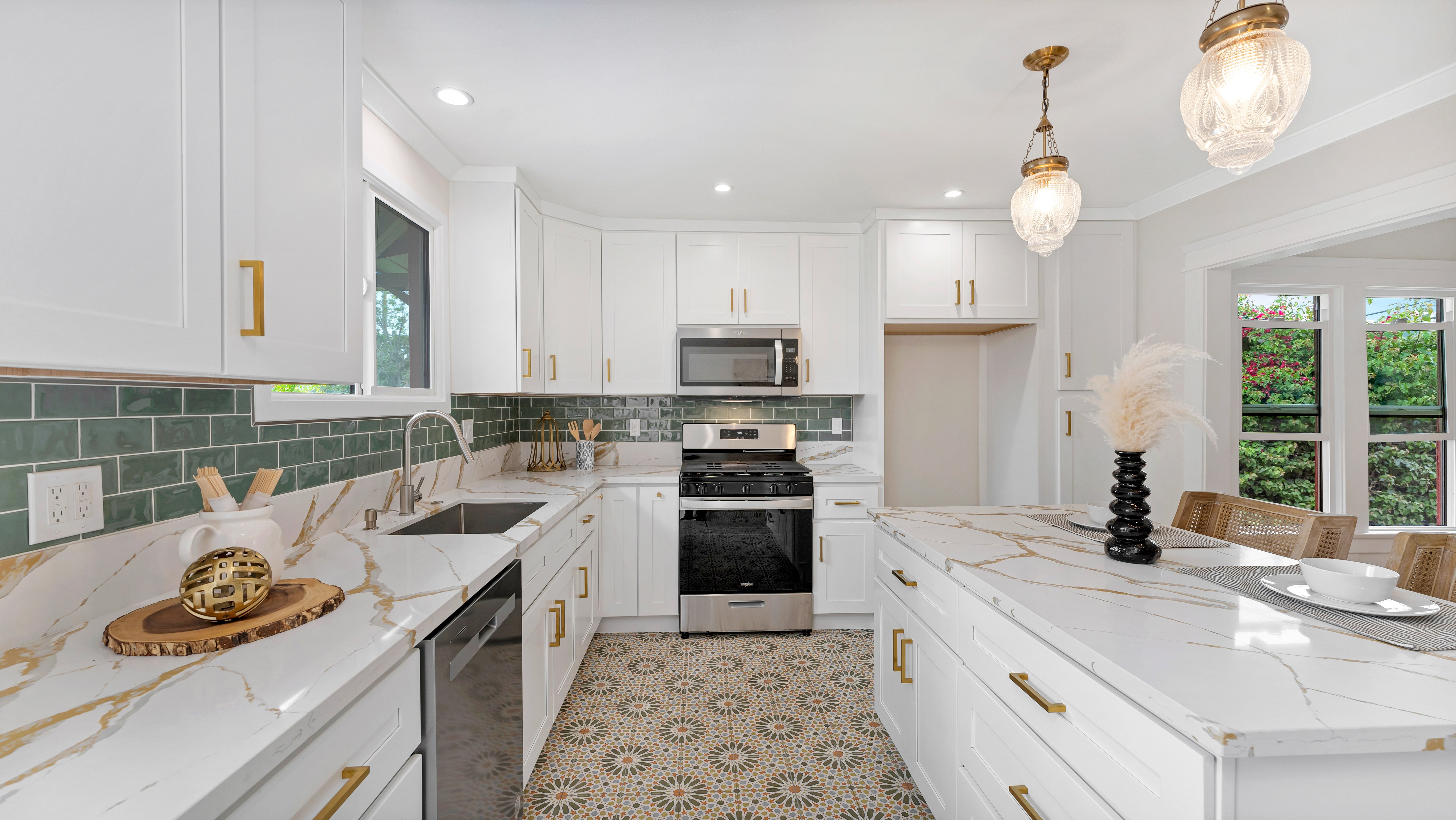Bright modern farmhouse kitchen with white cabinets, gold hardware, and patterned tile flooring.