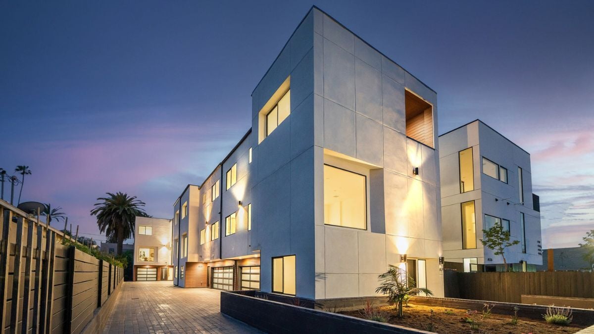 Luxury contemporary apartment building at dusk with large windows and modern exterior lighting