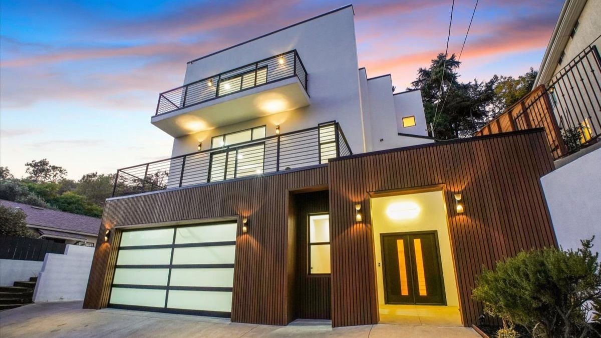 Luxury modern hillside home with rooftop terrace, glass garage door, and contemporary design