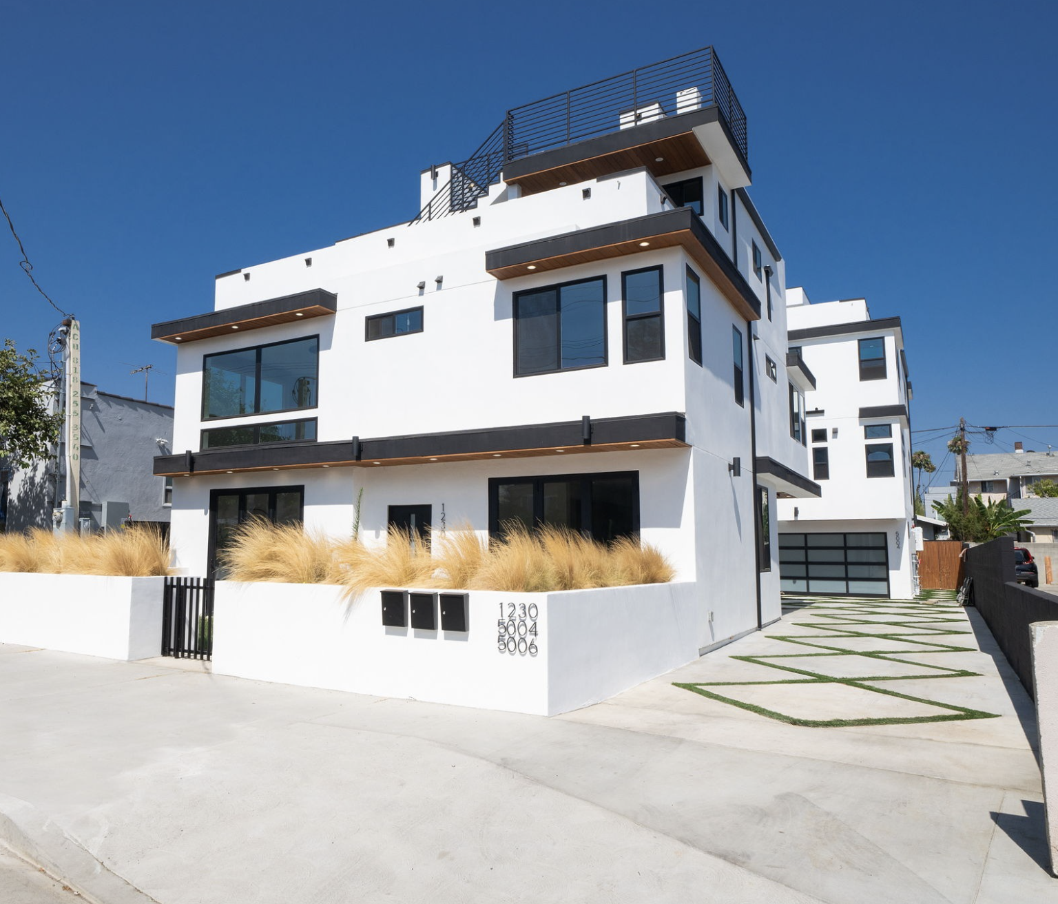 Modern multi-unit residential building with balconies and clean white façade.