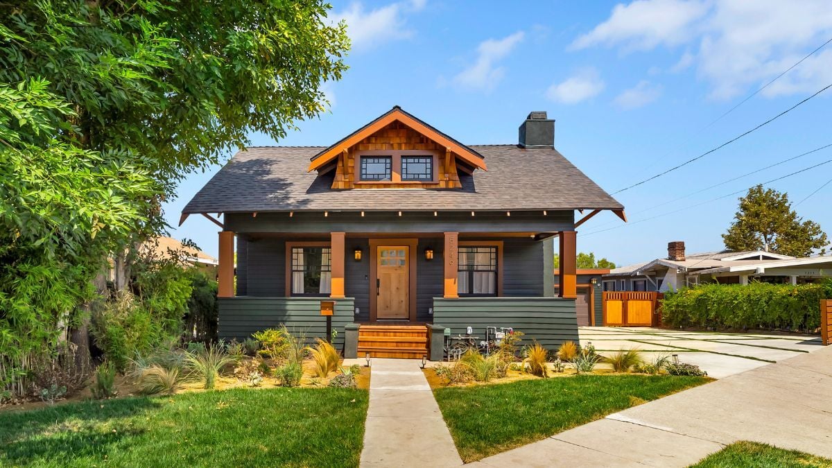 Rustic Craftsman-style home with wood accents, landscaped garden, and welcoming front porch
