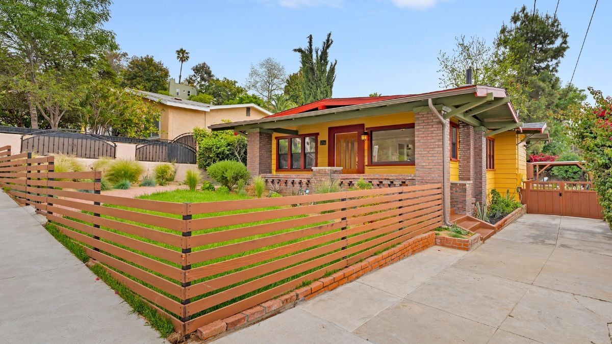 Single-story mid-century modern home with wood fencing and simple California ranch design