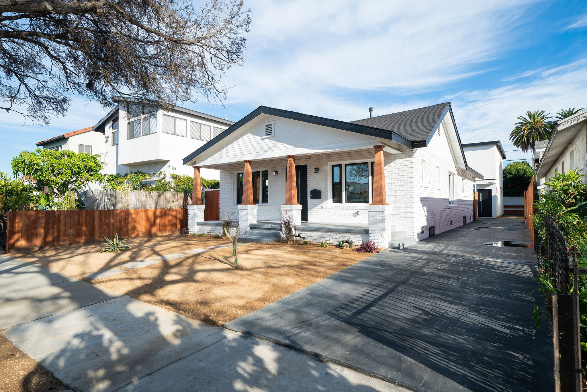 Single-family home under renovation with exposed framing and driveway.