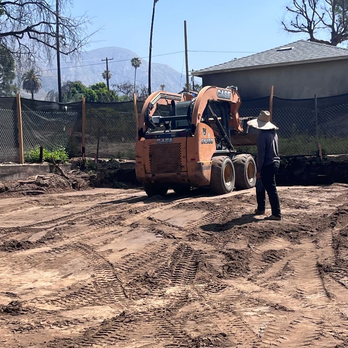 ATP Development & Construction site preparation showing Bobcat skid steer and mini excavator actively grading and mobilizing earth on a residential construction lot in the Los Angeles foothills area